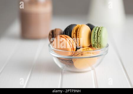 Dolce al macaron. Macaron colorati in ciotola sul tavolo bianco. Foto Stock