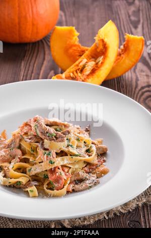 Pasta con pollo, funghi di ostrica e zucca secca al sole Foto Stock