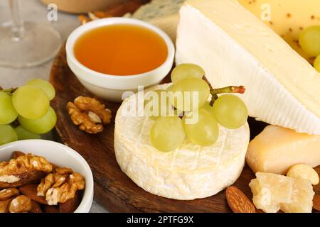 Piatto con gustosi formaggi e uva in tavola, primo piano Foto Stock