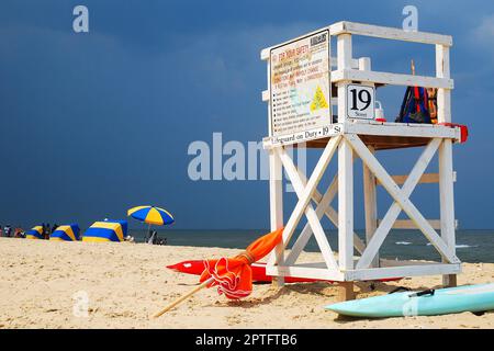 Le nuvole di tempesta si avvicinano rapidamente alla spiaggia in un giorno di vacanze estive, inducendo le persone ad abbandonare i loro ombrelloni a riva Foto Stock