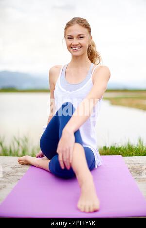 È un processo lento, ma la sua uscita non lo velocerà. una giovane donna che fa yoga all'aperto Foto Stock