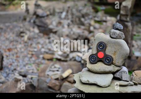 Un filatore in legno si trova su strane strutture di pietra nella foresta Foto Stock