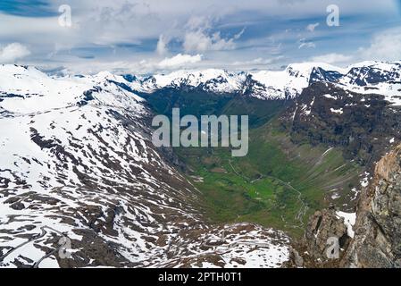 In cima a Dalsnibba, lo Skywalk di Geiranger con vista sulle montagne innevate e sul villaggio di Geiranger nella valle Foto Stock