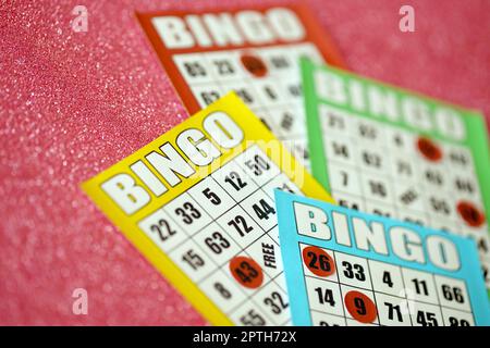 Molte tavole di bingo colorate o carte da gioco per vincere chip. Carte Bingo classiche americane o canadesi da cinque a cinque su sfondo luminoso Foto Stock