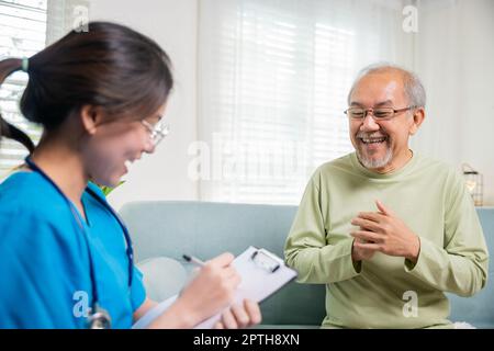 L'uomo anziano prende il medico nel paese che dice circa i reclami di salute, l'infermiera giovane asiatica che scrive la clipboard di prescrizione mentre parla durante la chiamata domestica sic Foto Stock