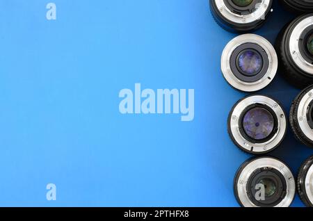 Diversi obiettivi fotografici si trovano su uno sfondo blu brillante. Spazio per il testo Foto Stock