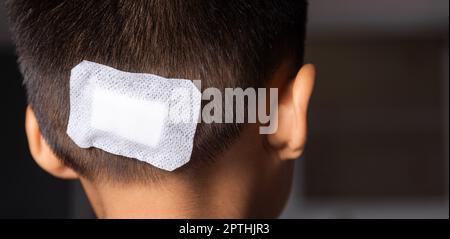 La ferita di sutura lacerata della testa posteriore del capretto che sutura con trauma la testa da bendaggio medico, cura medica della lesione chirurgica sulla testa, chil Foto Stock