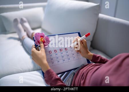 Donna africana che usa il ciclo mestruale o il calendario del periodo Foto Stock