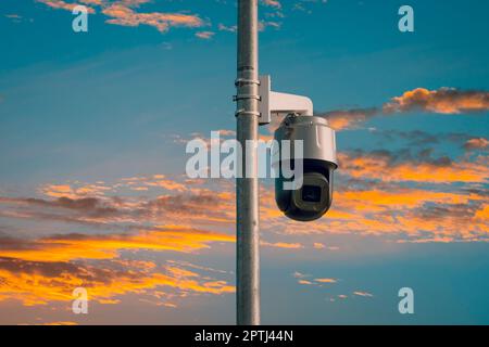 Telecamera CCTV di sicurezza su un palo con cielo tramonto. Il concetto di sorveglianza sera. Foto Stock