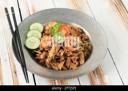 Spaghetti di riso piatto cinese fritto o Char KWAY Teow o Kwetiau con pesce, famoso cibo tra indonesiano, malese e singaporiano Foto Stock