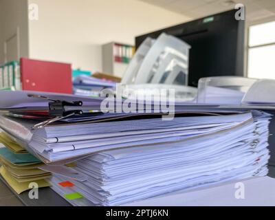 Pila di documenti documenti in archivi file con carta clip su tavolo in uffici, uffici occupati e pile di dati incompiuta cartelle sulla scrivania ufficio indo Foto Stock