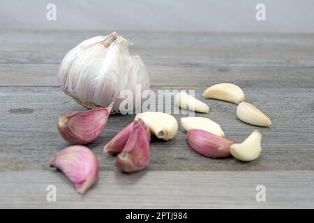 Testa d'aglio fresca con spicchi d'aglio sbucciati e non sbucciati Foto Stock