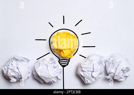 Idee creative e concetto di innovazione. Carta colore giallo palla scarto con simbolo lampadina Foto Stock