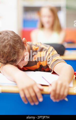 Investa in buoni supplementi della vitamina per aiutarli a fare il loro la cosa migliore. Ragazzo steso con le braccia sopra la scrivania, addormentato in mezzo alla classe - copyspace Foto Stock