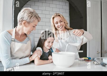 Cucina, apprendimento e famiglia in cucina con caraffa per preparare gli alimenti mescolando con sorriso. Felice, benessere ed eccitato bambino guardando madre poouri Foto Stock