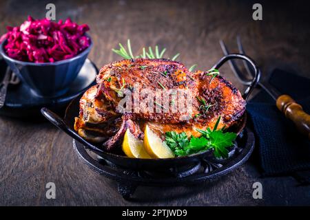 Stinco di tacchino arrosto con insalata di cavolo rosso sott'aceto su fondo in legno Foto Stock