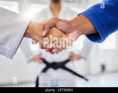 Stretta di mano, karate e sport con un combattente uomo e donna che scuote le mani in una palestra, club o dojo. Fitness, esercizio fisico e grazie con un maschio e una femmina Foto Stock