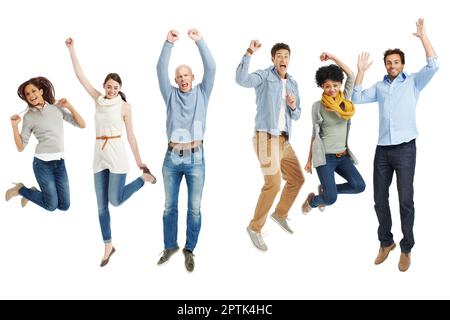 Celebrare il momento. Gruppo di giovani adulti vestiti casualmente che saltano eccitatamente su uno sfondo bianco Foto Stock