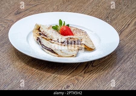 pancake con cioccolato e fragola. Foto Stock