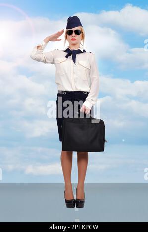 la stewardess in piedi sulla pista e sul cielo blu Foto Stock