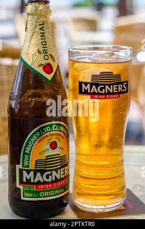 FUENGIROLA, SPAGNA - 10 OTTOBRE 2021: Bottiglia di sidro irlandese Magners, servita refrigerata in un bicchiere con il logo Magners Foto Stock