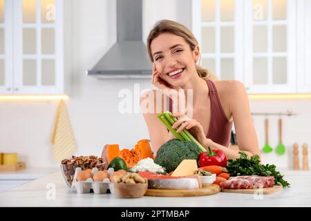 Donna con cibo sano in cucina. Dieta Keto Foto Stock