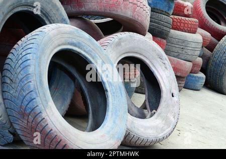 Una foto di molti vecchi pneumatici usati a sinistra su una discarica di rifiuti. La foto di un problema ecologico e di catastrofe Foto Stock