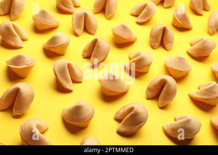 Molti biscotti gustosi della fortuna con le previsioni sullo sfondo giallo Foto Stock