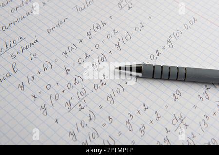 Carta con calcoli matematici scritti e penna, primo piano Foto Stock