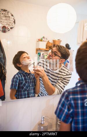 Padre che assiste suo figlio a radersi in bagno, Monaco, Germania Foto Stock