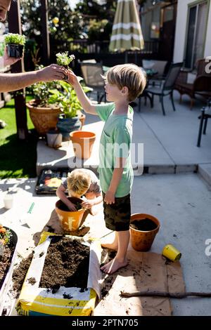 Nipoti che piantano con zio per la primavera a San Diego Foto Stock