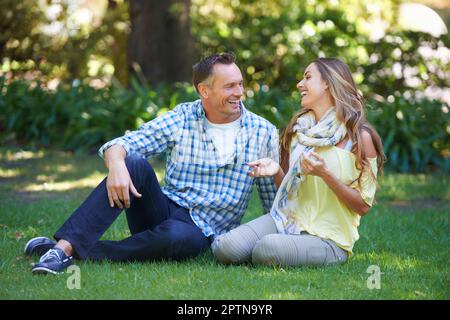 Trovare un posto tranquillo per chattare. una coppia affettuosa che si gode il sole estivo Foto Stock