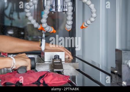 L'uomo impostare il comparatore per impostare il giusto equilibrio tra lavoro dopo il taglio del CNC Foto Stock