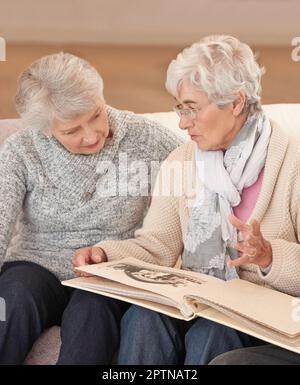 Alcuni ricordi non sbiadiscono mai. anziani che guardano attraverso un album fotografico Foto Stock