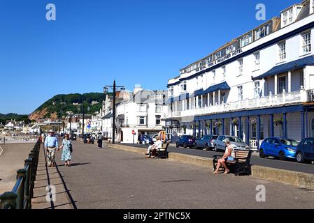 I turisti si godono la vista sul lungomare con la spiaggia a sinistra e il Royal York and Faulkner Hotel sul retro, Sidmouth, Regno Unito. Foto Stock