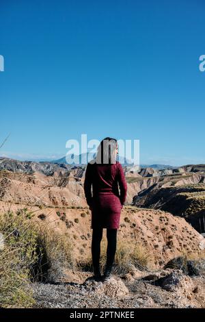 Una giovane donna con la schiena girò davanti all'ingresso di un deserto nel sud della Spagna. Foto Stock