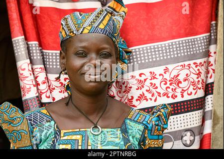 NIGER, Maradi, villaggio Dan Bako, donna in cera colorata abito stampato bambino di tenda colorata / Frau in einem farbigen Batik Kleid Foto Stock