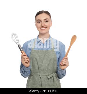 Bella giovane donna in grembiule pulito con utensili da cucina su sfondo bianco Foto Stock