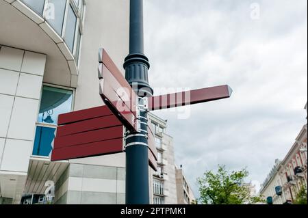 Posta con le indicazioni in bianco sulla strada della città, vista ad angolo basso Foto Stock