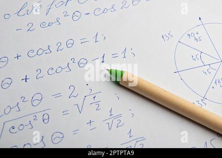 Carta con calcoli matematici scritti e penna, primo piano Foto Stock