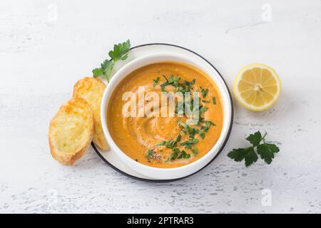 Zuppa di lenticchie con crostini di prezzemolo e formaggio su sfondo azzurro, vista dall'alto Foto Stock