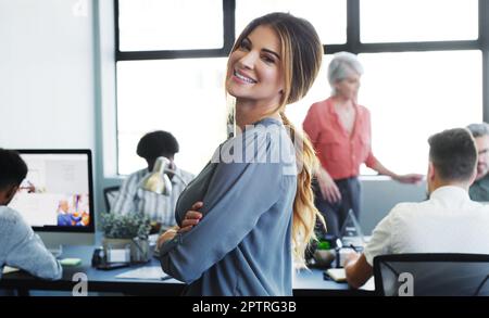 La giusta mentalità per mantenere motivata una squadra. Ritratto di una giovane donna d'affari fiduciosa che lavora in un ufficio moderno con i suoi colleghi nel Foto Stock
