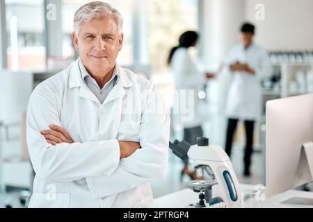 Amo cambiare il mondo attraverso la scienza. Ritratto di uno scienziato anziano in piedi con le braccia incrociate in un laboratorio Foto Stock