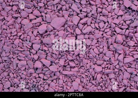 Texture da un mucchio di pietrisco, dipinto in colore rosa chiaro. Immagine di sfondo di molte pietre rosa di diverse forme e dimensioni Foto Stock