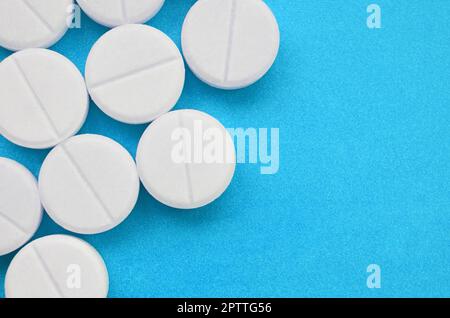 Un paio di compresse bianche giacciono su un blu brillante superficie di sfondo. Immagine di sfondo sul farmaceutico e medico, argomenti Foto Stock
