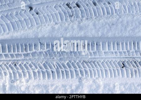 Vista ravvicinata dei cingoli degli pneumatici sulla superficie di neve fresca caduta Foto Stock