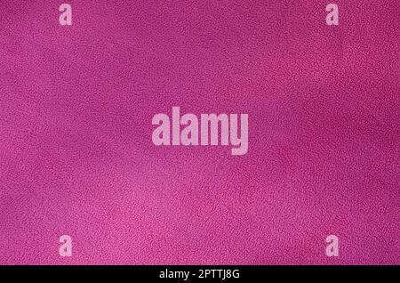 La coperta di pelliccia rosa in tessuto di pile. Una texture di sfondo di luce rosa peluche morbido materiale in vello Foto Stock