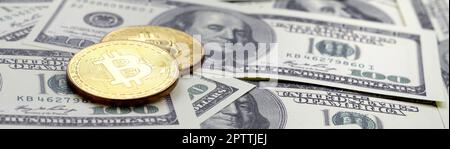 Golden bitcoins giacciono su un lotto di fatture del dollaro. Il concetto di alzare il prezzo dei bitcoin rispetto al dollaro statunitense Foto Stock