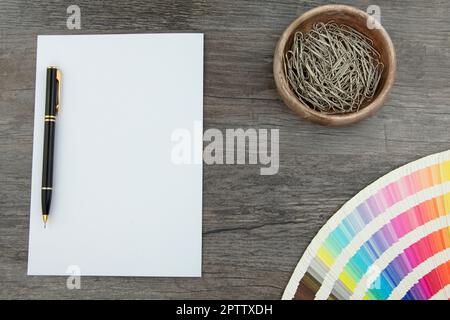 Vista dall'alto delle schede bianche e delle gamme di colori vuote su un'asse di legno Foto Stock