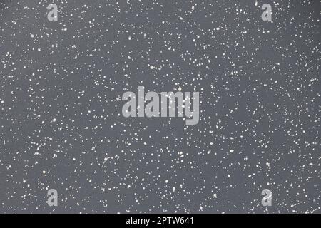 Texture o carta da parati, rivestimento antiaderente in granito. Piccole macchie bianche e nere su sfondo grigio. Alta risoluzione. Profondità di campo completa. Foto Stock